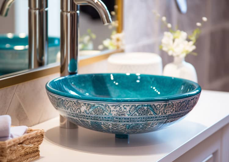 Un lavabo de salle de bain au design bleu et blanc.