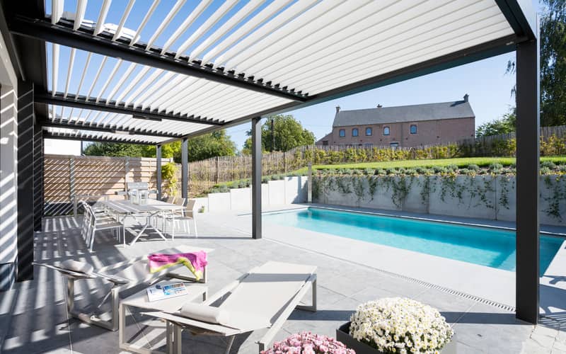 Un patio avec piscine et pergola.